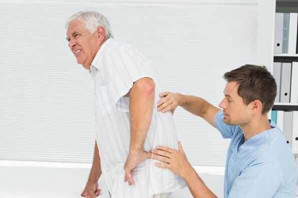 Elderly patient with low back pain being examined by a doctor